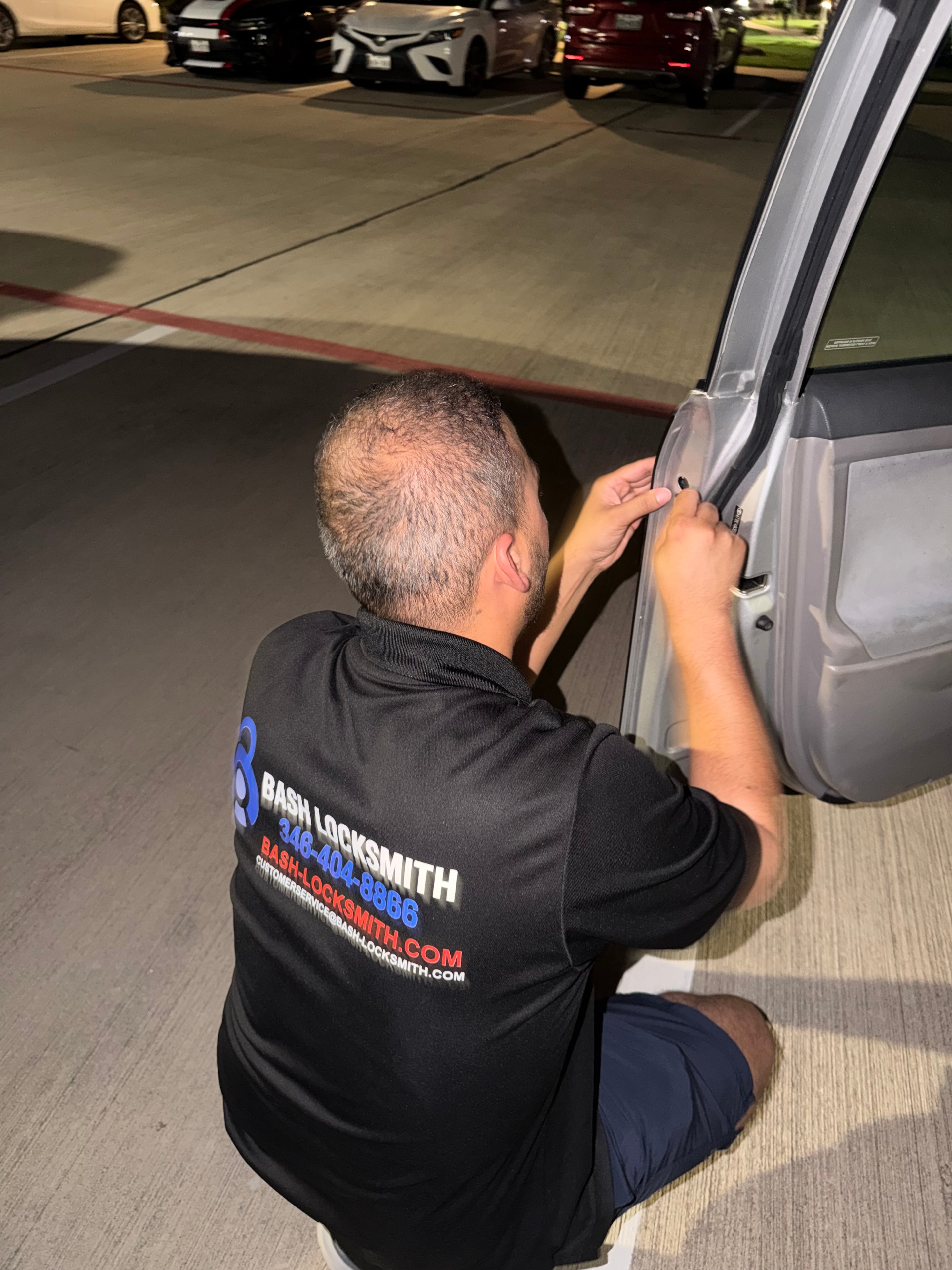 Locksmith working on vehicle door