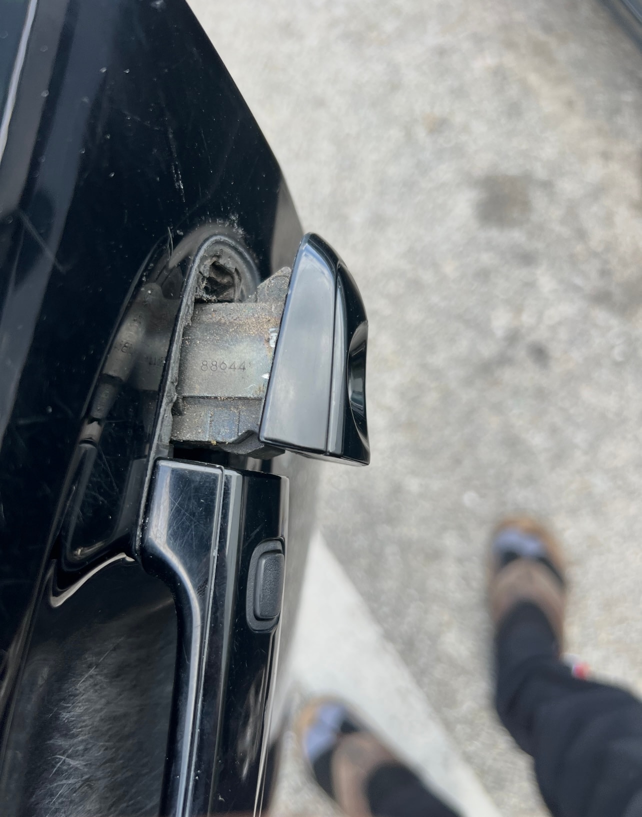 Car side mirror and damaged concrete wall