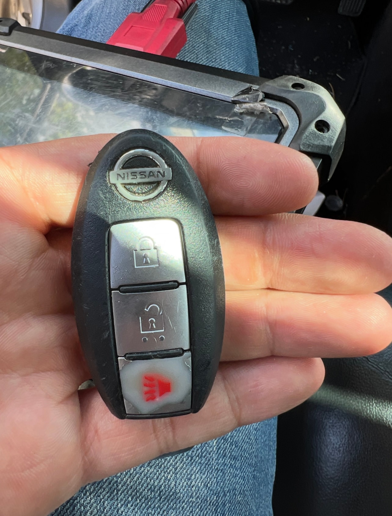 Hand holding Nissan car key fob