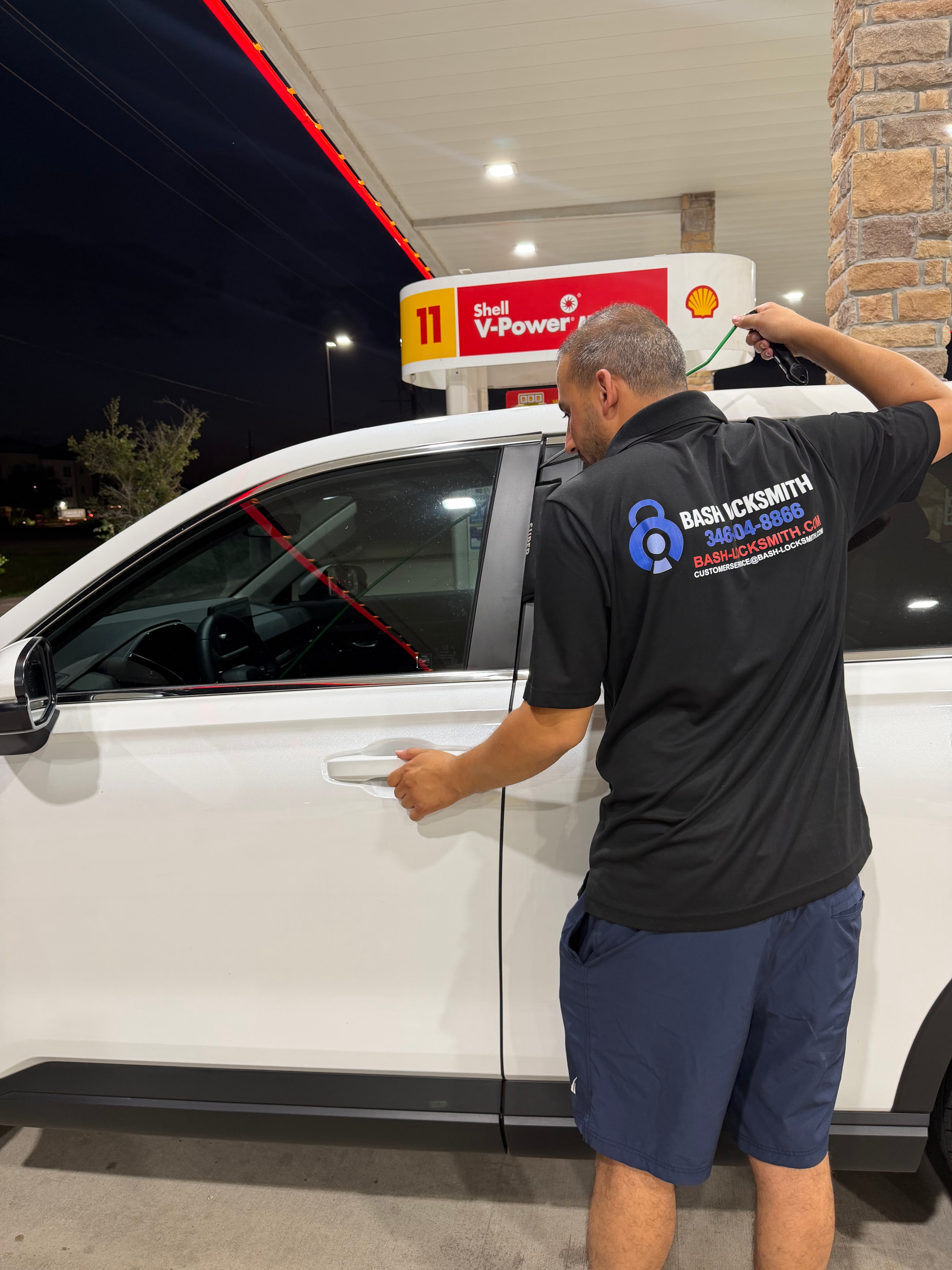 Locksmith opening car door at gas station