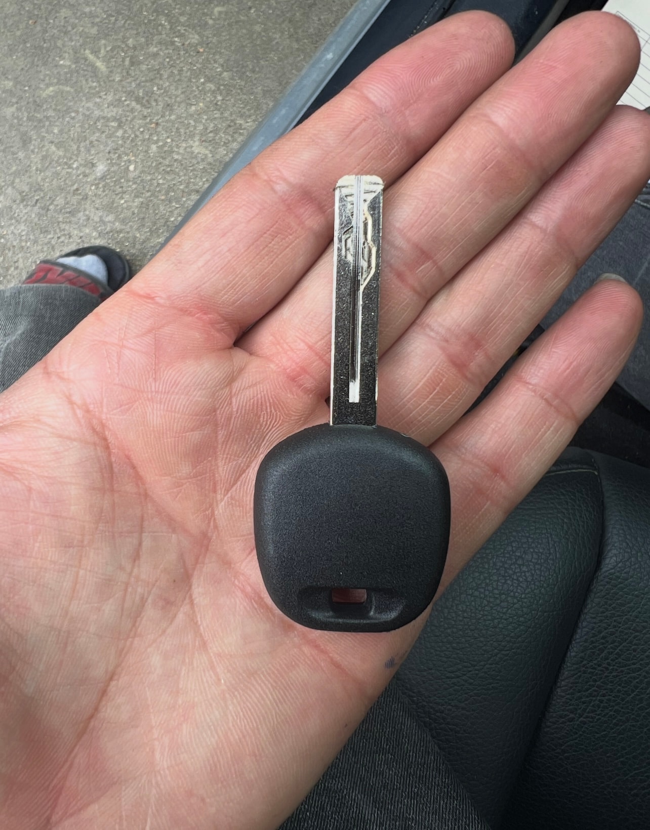 Hand holding black car key fob
