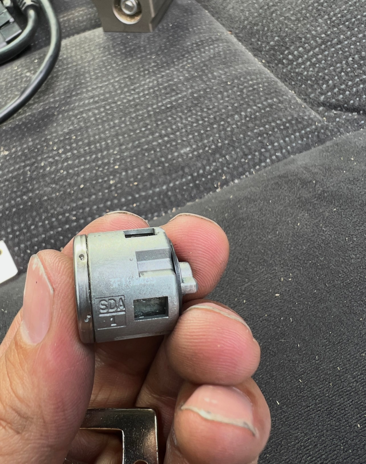 Hand holding small metal motor component